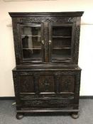 A nineteenth century carved oak coffer with two door cupboard above