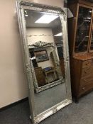 A large ornate silvered bevelled mirror