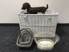A large wicker hamper containing wicker and metal baskets, wall rack,