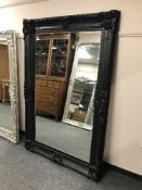 A large ornate black bevelled mirror
