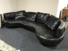 A large black leather Natuzzi shaped settee with adjustable back rests