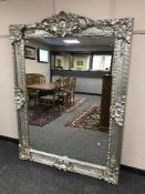 A large ornate silvered mirror,