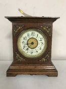 An early 20th century walnut cased musical mantel clock with enamel dial