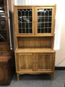 An oak leaded glass door dresser