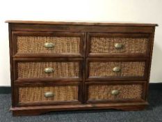 A stained pine wicker fronted six drawer chest