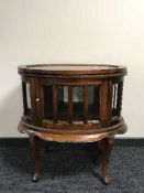 An oval mahogany cocktail cabinet with lift off tray