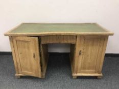 An Edwardian pine twin pedestal desk with green leather top