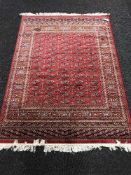 A Persian Bokhara rug on red ground,