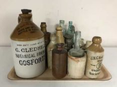 A tray of vintage stoneware and glass bottles and flagons