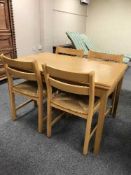 A contemporary extending table and four beech chairs