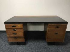 A mid twentieth century teak twin pedestal desk with leather top