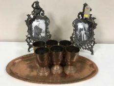 An oval copper serving tray with six goblets,
