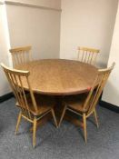 A mid 20th century extending teak dining table plus two leaves and four Ercol chairs