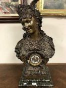 A patinated figural mantel clock with enamel dial,