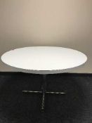 A circular melamine topped dining table