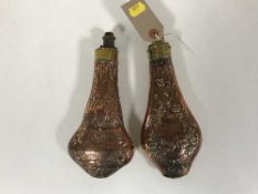 Two embossed copper and brass shot flasks