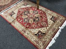 A fringed Persian Heriz rug on red ground 190 cm x 140 cm