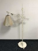 An early 20th century wrought iron adjustable standard lamp