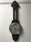 A carved oak aneroid barometer