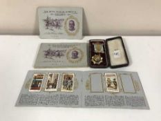 A cased roll of honour medal and four W D & H O Wills Silver Jubilee cigarette card albums