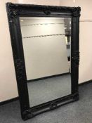 A large black ornate framed bevelled mirror 121 cm x 181 cm
