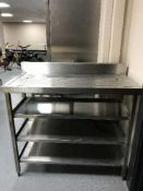 A stainless steel four tier fish preparation stand with drainer