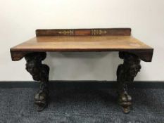 A Victorian inlaid rosewood side table on a pair of heavily carved mahogany legs