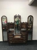 A three piece carved mahogany bedroom suite comprising of mirrored wardrobe,