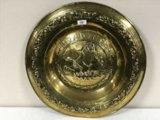 A early 20th century brass embossed charger