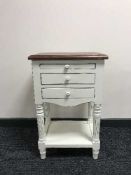 A white side table fitted three drawers