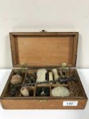 A gun cleaning kit in a fitted pine box