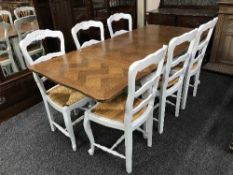 A French oak extending oak table on painted base together with six rush seated chairs