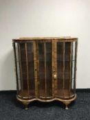 A shaped walnut display cabinet