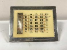 A silver mounted desk calendar