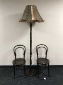 A standard lamp with shade and a pair of Bentwood chairs