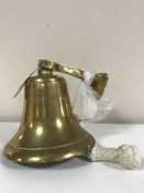 A brass ship's bell and a brass desk top flag pole
