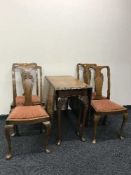 A walnut Queen Ann style drop leaf table together with four oak chairs