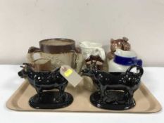 A tray of late 19th century and 20th century pottery jugs and two cow creamers