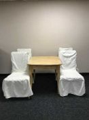 An extending beech kitchen table and four chairs