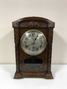 An oak bracket clock with silvered dial
