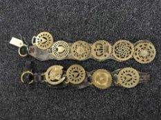 Nine early 20th century horse brasses on two leather straps
