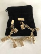 A gilt D & G Charm bracelet in pouch