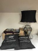 A box containing linen, cushions, leather place mats and coasters, wall hangings,
