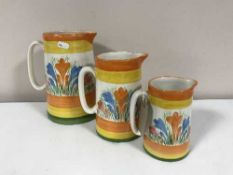 A set of three graduated jugs in Clarice Cliff style