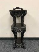 A Chinese carved three tier stand with rouge marble top,