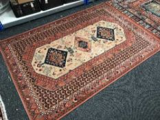 Two contemporary woollen eastern rugs on rust coloured ground