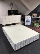 A 5' divan base together with a cream upholstered headboard