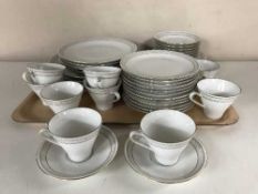 A tray containing a German white and gilt tea and dinner service