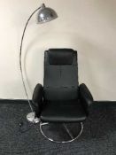 A black swivel armchair together with a chrome metal floor lamp