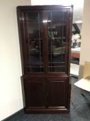 A mahogany double door glazed corner cabinet fitted cupboards below